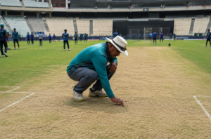Ground staff inspect a cricket pitch before an international match.