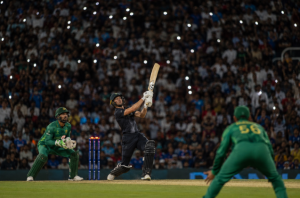 Generic cricketers compete during a packed T20 match under floodlights.