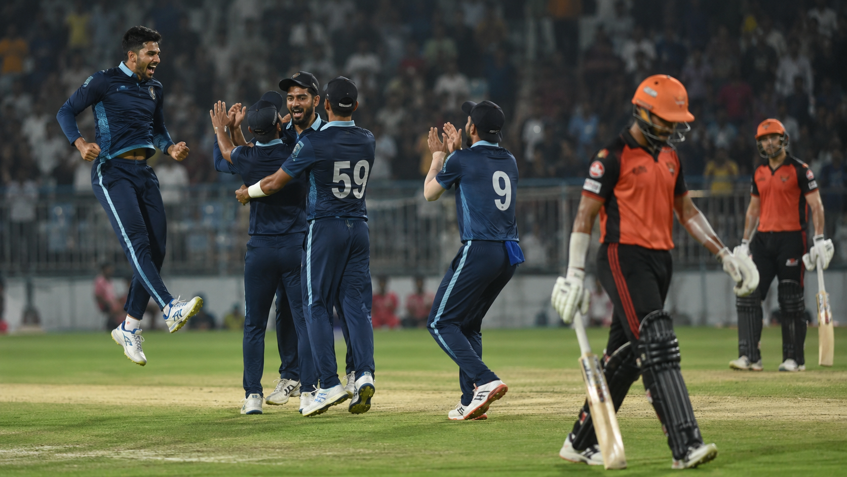 Generic T20 fielders celebrate under lights after a batting collapse in Ahmedabad