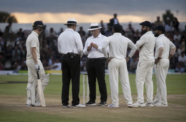 Umpires inspect a pink cricket ball as the ICC approves new Test cricket playing-condition trials.