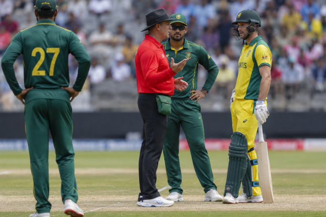 Umpires speak to an India A batter during a rare penalty incident against Sri Lanka A.