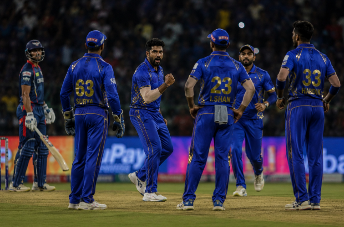 Mumbai Indians players celebrate a middle-overs breakthrough during an IPL 2026 match.