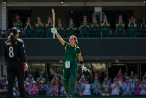 Generic South African batter celebrates a century during a Women's T20 World Cup match.
