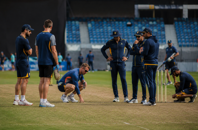 Players and coaches inspect a cricket pitch before the ODI World Cup as discussions around playing conditions continue.